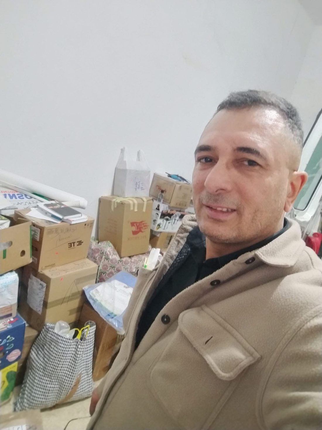 Le responsable de Mehdi Transport devant les cartons préparés pour le départ